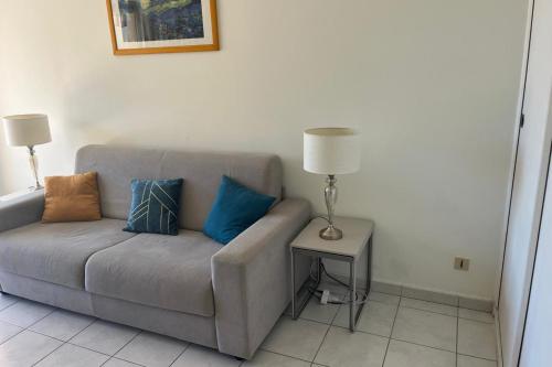 un canapé avec des coussins dessus dans un salon dans l'établissement Residence quiet and wooded near beach, à Saint-Raphaël