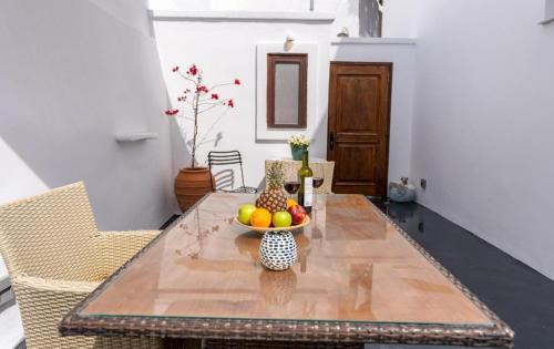 a dining room table with a bowl of fruit on it at Argy's Luxury Caves in Megalokhori