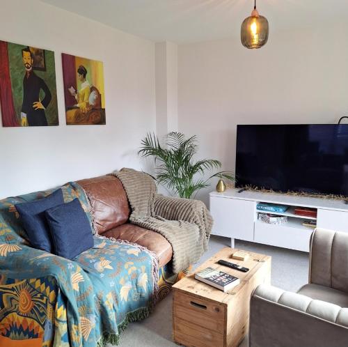 a living room with a couch and a flat screen tv at 3 bed house Stratford-upon-Avon, River, Theatre and Restaurants in Stratford-upon-Avon