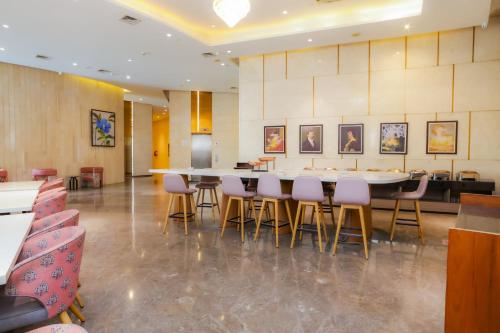 a dining room with a large table and chairs at Hotel Livbox at Supernova in Noida