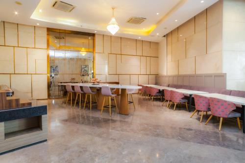 a restaurant with tables and chairs in a room at Hotel Livbox at Supernova in Noida