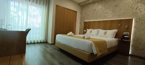 a bedroom with a large bed and a large window at Hotel Império do Norte in Ponte de Lima
