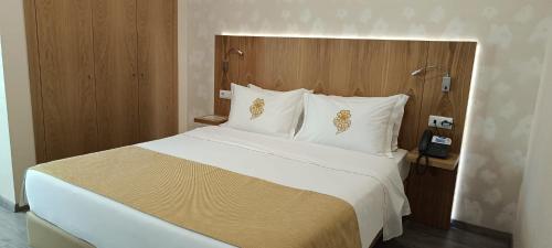 a bedroom with a large white bed with a telephone at Hotel Império do Norte in Ponte de Lima