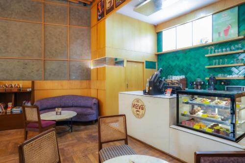 a restaurant with a counter and a table and chairs at Hotel Livbox at Supernova in Noida
