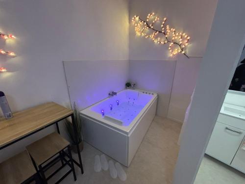 La salle de bains est pourvue d'une baignoire avec des lumières violettes. dans l'établissement Tokyo love, à Montpellier