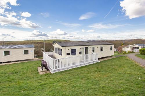 a mobile home with a porch on a lawn at Holiday Home in Hastings in Hastings