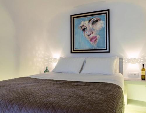 a bedroom with a bed with a painting on the wall at Argy's Luxury Caves in Megalokhori