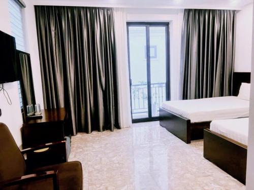 a hotel room with two beds and a balcony at Homestay Sunny in Thái Nguyên