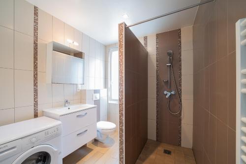 La salle de bains est pourvue d'un lavabo et d'une douche. dans l'établissement Villa Welcom 2 - 3 min à pied de la plage, à Canet