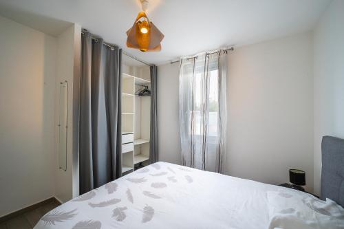 une chambre avec un lit et un ventilateur de plafond dans l'établissement Villa Welcom 2 - 3 min à pied de la plage, à Canet