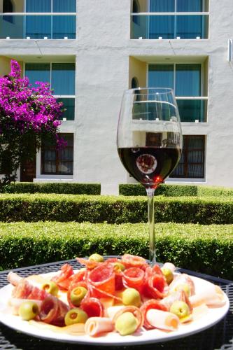 a plate of food and a glass of wine at Hotel Posada Señorial in Cholula