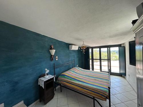 a bedroom with a bed with a blue wall at Villa CHIA in Chia