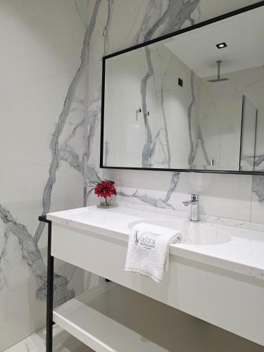 a bathroom with a white sink and a mirror at Valza Boutique Hotel in Vlorë