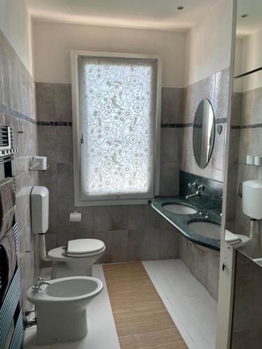 a bathroom with a toilet and a sink and a window at Rooftop open space in Stra