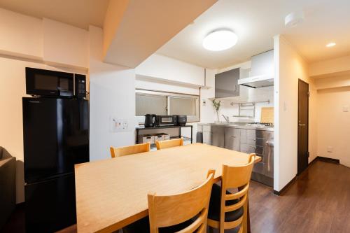 a kitchen and dining room with a wooden table and chairs at ホテル富士見マンション in Tokyo