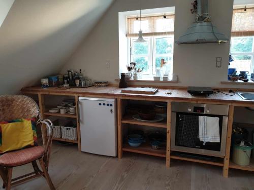 a kitchen with a wooden counter with a white refrigerator at Lejlighed nær badesø in Årslev
