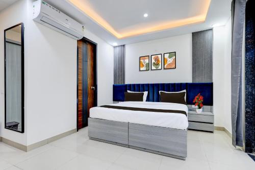 a bedroom with a king sized bed and a blue headboard at The Byke Business Hotel - Sector 29 in Gurgaon
