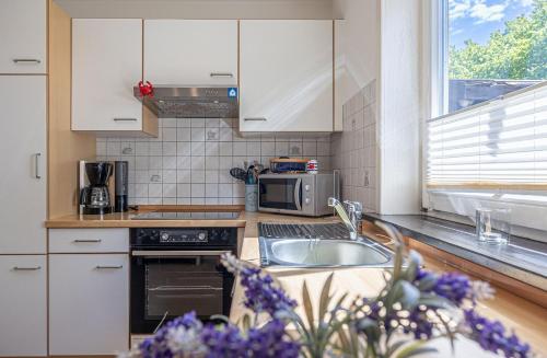 a kitchen with a sink and a microwave at Ferienhaus Nordlicht in Steinbergkirche