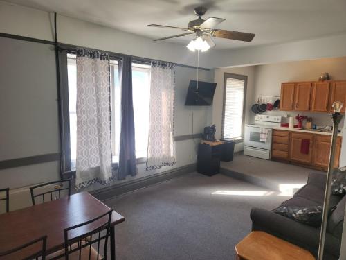a living room with a ceiling fan and a table at Goose's Hall 