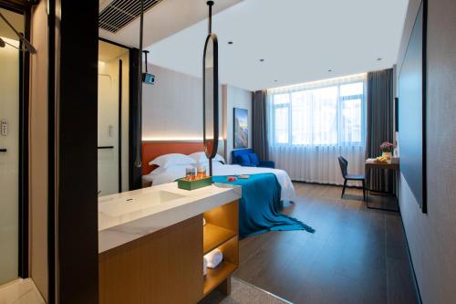 a hotel room with a bed and a bathroom at ME Hotel in Huangshan
