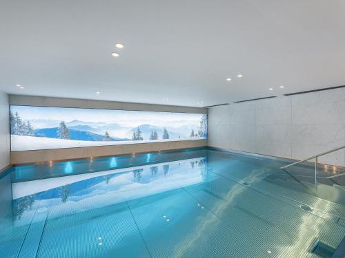 - une piscine dans une maison avec une grande fenêtre dans l'établissement Duplex avec espace détente, piscine et 4 chambres à Megève - FR-1-569-66, à Megève