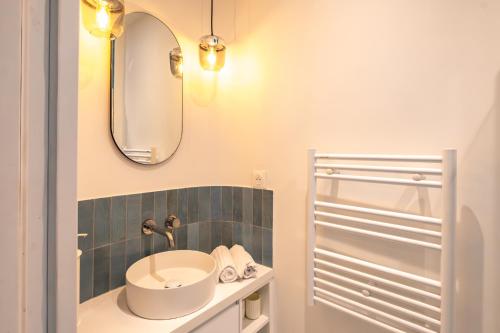 un baño con lavabo y espejo en 4 Guest - Hausmanian Flat Arc de Triomph, en París