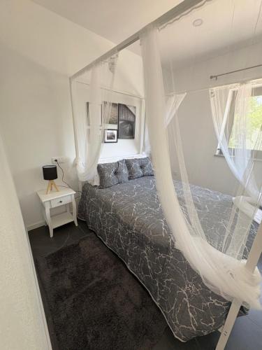 a bedroom with a canopy bed with white curtains at Casa Gidelos in Geres