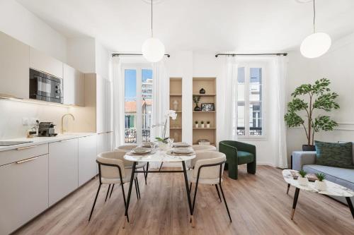 une cuisine et un salon avec une table et des chaises dans l'établissement Appartement Caire - Welkeys, à Cannes