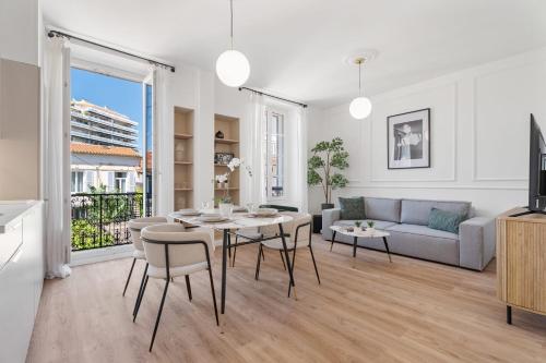 un salon avec une table, des chaises et un canapé dans l'établissement Appartement Caire - Welkeys, à Cannes