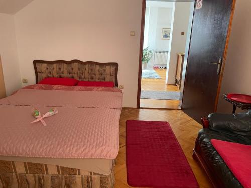 a bedroom with two beds with red pillows at Apartman 1 in Krnjača