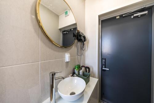 a bathroom with a sink and a mirror at Hongdae Sinchon Theme Motel in Seoul