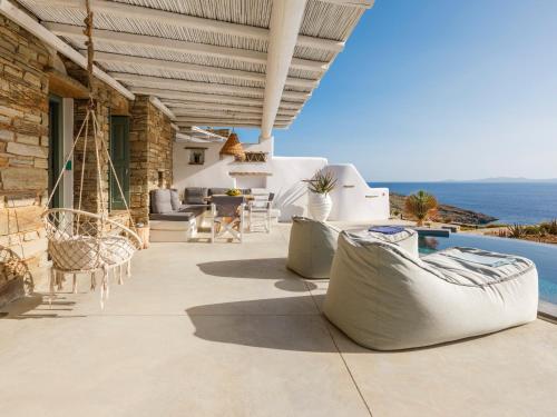 a patio with chairs and a table and a pool at Tinostra Casa in Agios Romanos