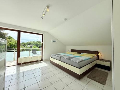 ein Schlafzimmer mit einem Bett und einem Balkon in der Unterkunft 23 Lake Harmony in Sipplingen