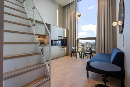 a room with a staircase and a blue chair at Unity Helsinki - A Studio Hotel in Helsinki