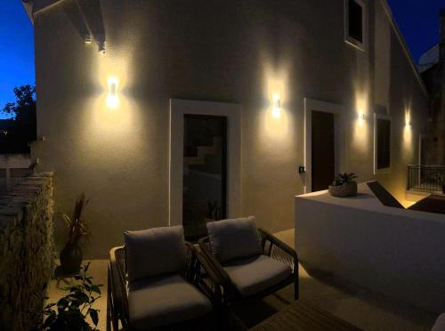 a patio with two chairs and a table and lights at C a s a B e a s t in Split