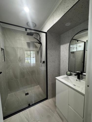 a bathroom with a glass shower and a sink at Teresa Ct in Rye