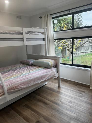 a bedroom with bunk beds and a large window at Teresa Ct in Rye
