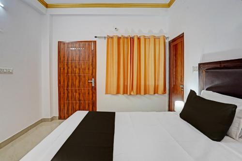a bedroom with a bed and a wooden door at Hotel O RR Palace in Bheta