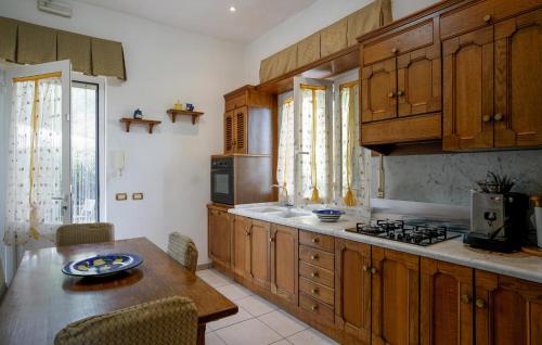 a kitchen with wooden cabinets and a table and a stove at Beautiful Home In Corsanico in Corsanico-Bargecchia