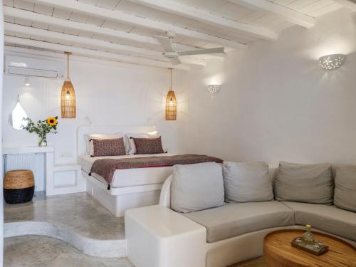a white bedroom with a bed and a couch at Tinostra Casa in Agios Romanos