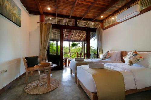 Un dormitorio con una cama, una mesa y un sofá. en Kaloi Villa, en Bedahulu