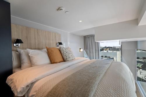 a bedroom with a large bed with a large window at Unity Helsinki - A Studio Hotel in Helsinki