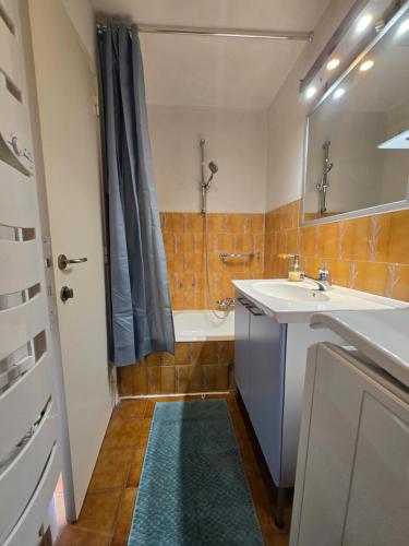 une salle de bain avec un lavabo, une baignoire et une douche dans l'établissement Appartement mer et centre ville, à Sainte-Maxime