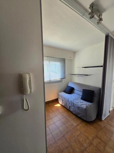 un salon avec un canapé bleu dans une pièce dans l'établissement Appartement mer et centre ville, à Sainte-Maxime