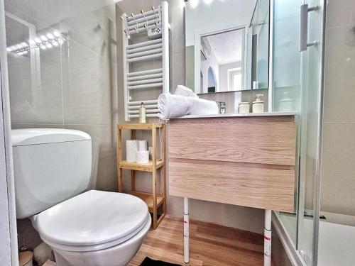 une salle de bain avec toilettes, lavabo et miroir dans l'établissement Lumineux et charmant deux pièce - Menton, à Menton