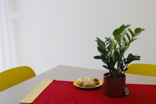a plate of food on a table with a plant at Sipala Home Appartamento Acireale Centro in Acireale