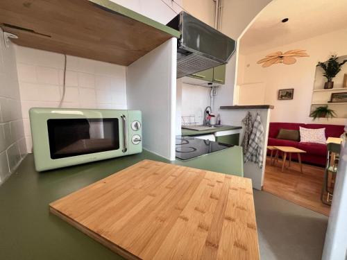 un micro-ondes posé sur un comptoir dans une cuisine dans l'établissement Lumineux et charmant deux pièce - Menton, à Menton
