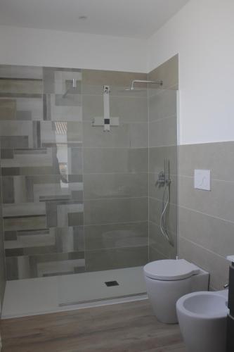 a bathroom with a shower and a toilet and a sink at Sipala Home Appartamento Acireale Centro in Acireale
