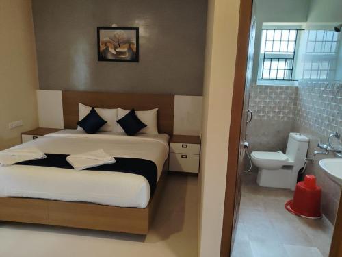 a bedroom with a bed and a bathroom with a sink at The Pearl Residency 2BHK 3BHK Apartments in Ooty