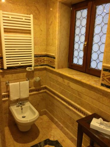 a bathroom with a toilet and a window and a sink at Bellevue Luxury Rooms - San Marco Luxury in Venice